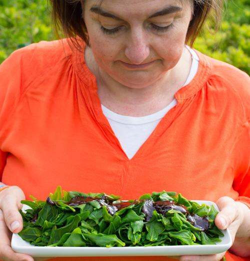 jaci holding a plate of warrigal greens with oyster sauce